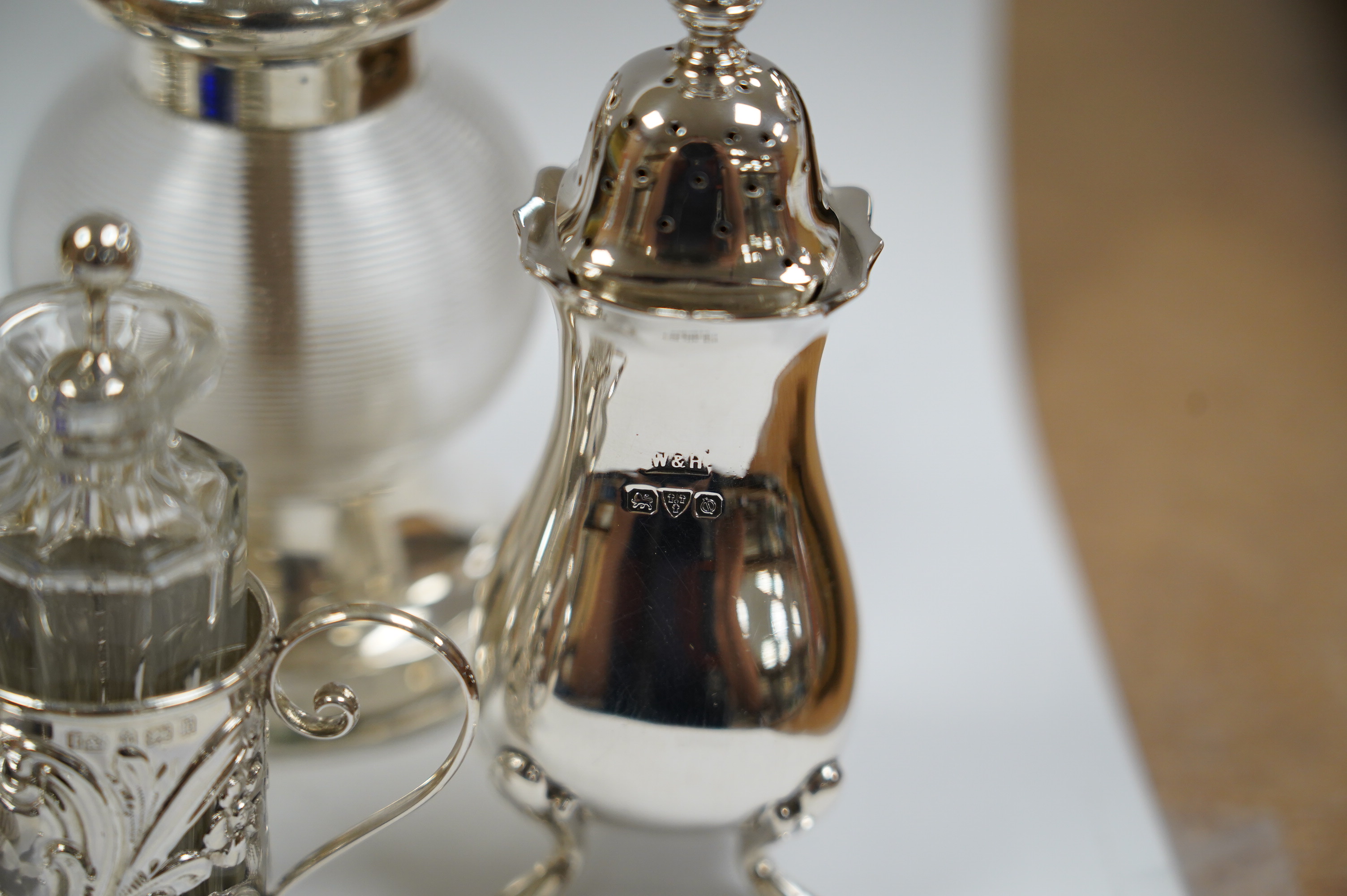 Six assorted silver condiments including a mounted ribbed glass pepper grinder and an Edwardian mounted glass cayenne pepper condiment, Condition - fair to good